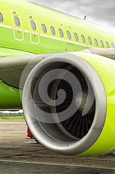 close-up of aircraft engine. green airplane and turbine detail on cloudy sky background at dawn