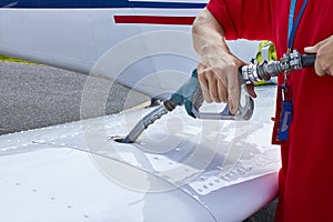 Close up of an aircraft worker fueling low-wing propeller driven airplane