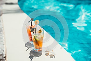 close-up of alcoholic drinks, ice and gin and tonic lemonade and mojito with lime served cold at pool bar