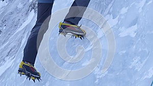 CLOSE UP Alpinist sticks his crampons in the ice while climbing up frozen stream