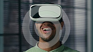 Close-up amazed african american man with VR glasses playing video game in digital metaverse world male gamer