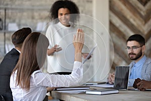 Close up ambitious female employee raise hand ask question.