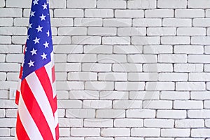 Close-up of the America flag against white brick wall background