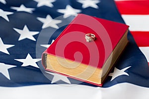 Close up of american flag, wedding rings and bible