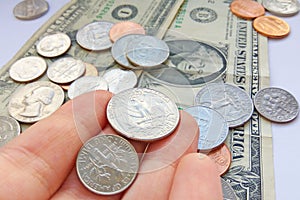 American quarter, dime coins in hand on dollar usa background