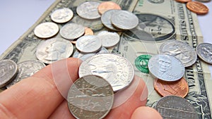 American quarter 25 cents, dime coins in hand on dollar usa background