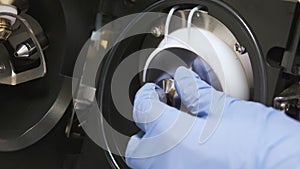 Close up analytical chemist removes the spray shield of mass spectrometer. Maintenance of LC MS qTOF