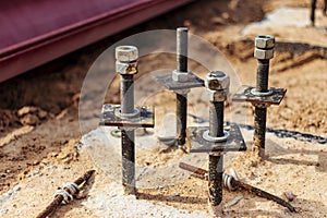 Close up the anchor bolts in concrete base of new edifice with reinforcement at building site