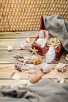 Close up Ancient casket for jewelry with collection of different seashells on wooden table