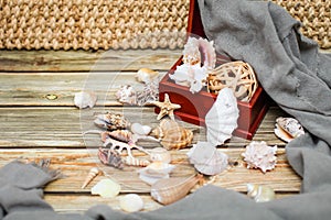 Close up Ancient casket for jewelry with collection of different seashells on wooden table
