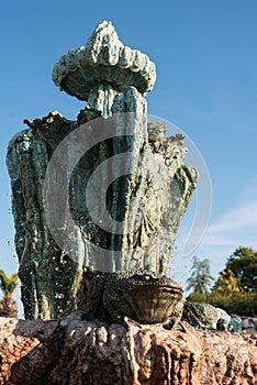 Close up of ancient stone, limestone fountain with frog in front. Located in the garden of an old fairy-tale castle.