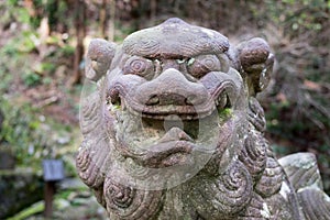 Close-up of ancient stone lion-dog sculpture next to Yoro waterfall. Gifu