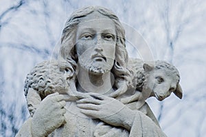 Close up ancient stone statue of Jesus Christ Good Shepherd with the lost sheep on his shoulders