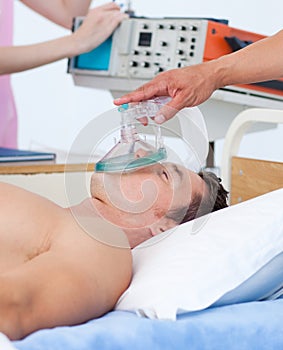 Close up of an anesthetist putting oxygen mask on