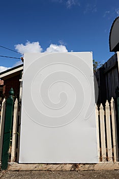 Close up on an angle of blank real estate sign outside a suburban residential property