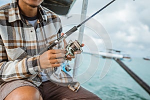 close up of angler's hand checking reel while holding rod