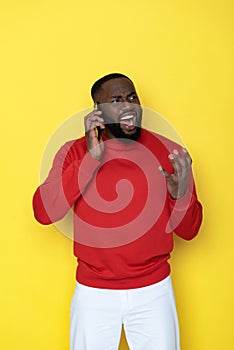 Close up of angry African man screaming by smartphone in studio