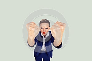 Close up angry young woman showing fists about to punch hit someone to have nervous atomic breakdown isolated light white green