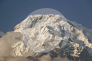 close up Annapurna South peak full with first whit snow in winter with sunset sunlight