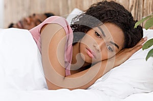 Close up of annoyed woman laying next to snoring husband