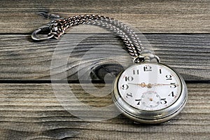 Close up of an antique pocket watch on an antique wooden table