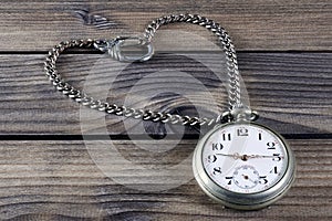 Close up of an antique pocket watch on an antique wooden table