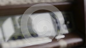 Close up of the antique radio set, vintage background with the reflection of a man and a window on glass panel. Action