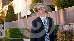 CLOSE UP: Anxious yuppie exhales while walking back home from work at sunset. photo