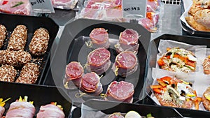 Close Up Appetizing meat products are on display in special containers. Meat products for sale in a supermarket window.