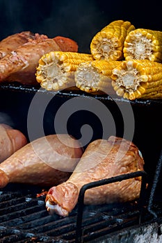 Close-up of appetizing turkey legs on the grill with corn cob. Concept summer picnic outdoors
