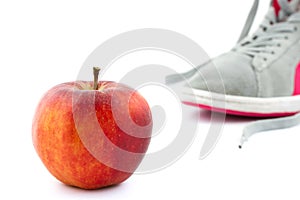 Close-up of an apple and sneaker on the background