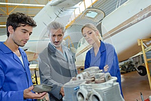 Close up apprentices with airplane parts