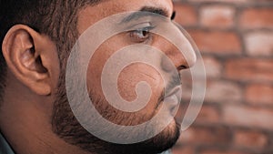 Close up arabian male face profile view on brick background. Portrait handsome man with black beard. Bearded man face.