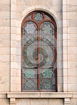 Close up of arched green detailed stained glass church window in Cradock