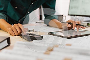 Close up Architect or Engineer pressing on calculator for calculating value estimating for safety with the drawing construction bu