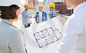 Close up of architects with blueprint at building
