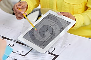Close up of architects with blueprint on tablet pc