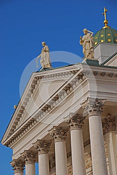 Close up architecture of Helsinki Cathedral top facade with green dome and statue, Finland
