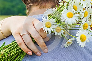 Close up of arm with bouquet camomile