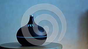 Close up of aroma oil diffuser on the table at home, steam from the air humidifier. Concept. Ultrasonic technology