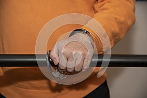 Close-up. Arrested man handcuffed hands at the back isolated on gray background