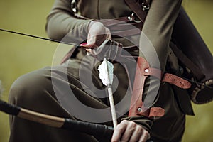 Close-up. Arrows and bow in female hands. Archery man in medieval costume