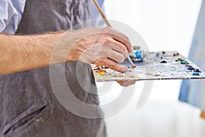 close-up artist& x27;s hands with palette and brush