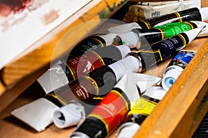 A close up of an artist`s work drawer filled with acrylic/oil paints