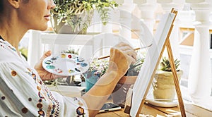 Close up of artist woman painting creative canvas in outdoor home hobby leisure activity. Happy female people enjoying colors and