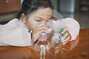 Close up asian child girl drawing cartoon on plastic bottle to recycle to be a flower pot. Kids arts and crafts creative activity