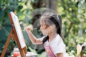 Close up of Asian child girl is painting on the canvas.