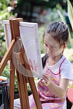 Close up of Asian child girl is painting on the canvas.