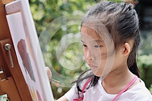 Close up of Asian child girl is painting on canvas.