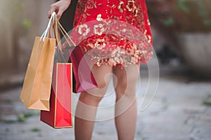 Asijský čínština žena v tradiční šaty držení nakupování taška v čínština nový 